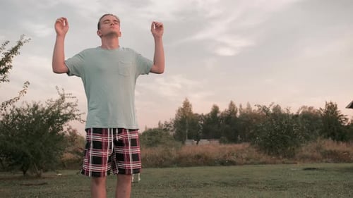 Man Meditating in a Rural Setting at Sunset
