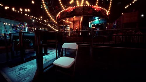 Lonely Chair at a Brightly Lit Empty Amusement Park During Nighttime
