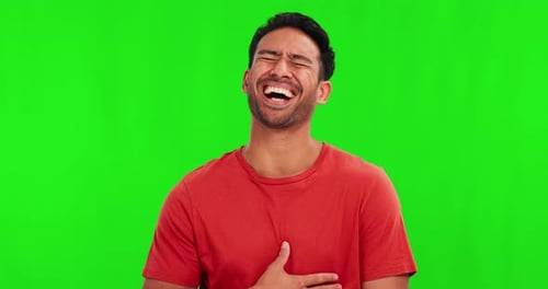 Comic, funny or laughter with a man on a green screen background in studio for humor or joking