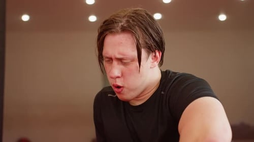 Male Fighter Exhausted After Intense Workout in Gym