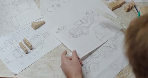 Adult Drawing a Car Design with Ruler