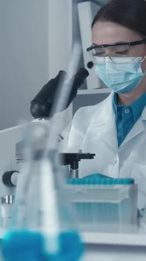 Woman Scientist Working With Microscope in Laboratory