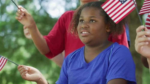 Children waving American flags outdoor on a sunny day