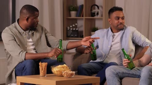 Three friends talk and drink beer at home
