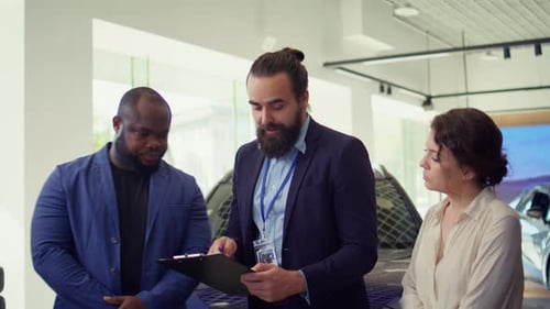 Friendly Car Salesman Showcasing Dealership Vehicles to Clients