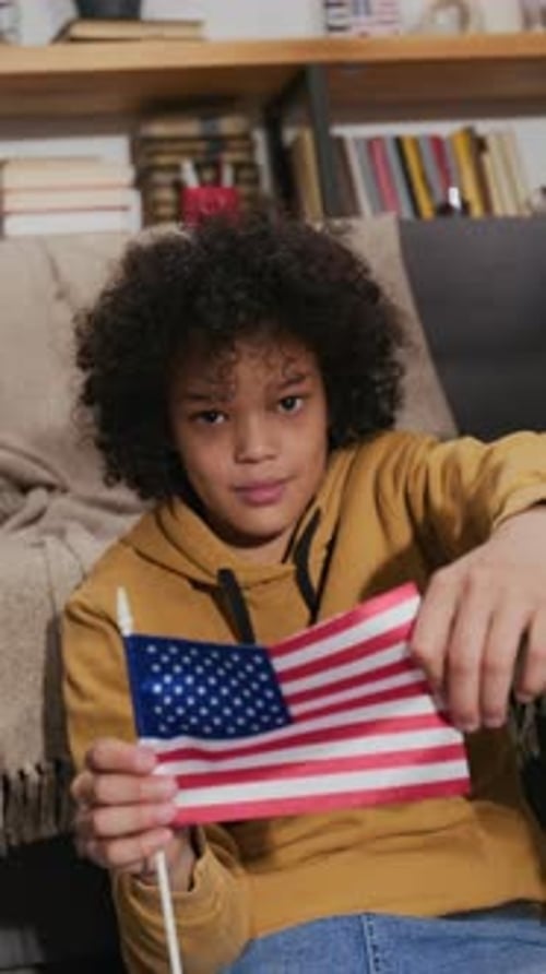 Smiling Child Holding an American Flag Indoors