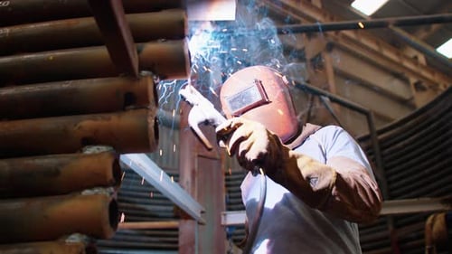 Metallschweißer, der mit einem Lichtbogenschweißgerät arbeitet. Professionelle Kleidung von Ingenieuren und Arbeitern in der Schwerindustrie