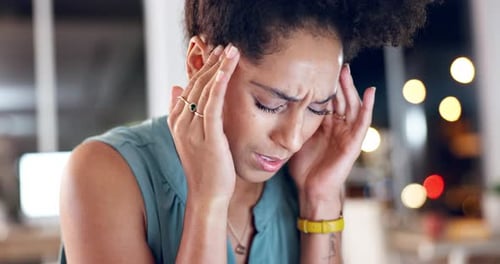 Stressed Woman Holding Head at Workplace at Night