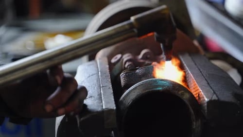 Close Up of Metalwork in Progress A Torch Flame is Applied to a Pipe or Cylindrical Metal Object