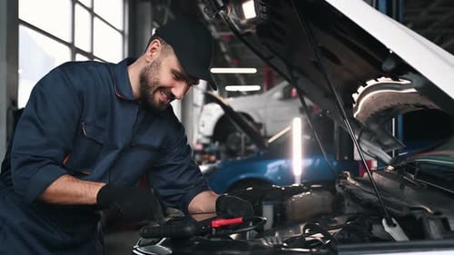 Connecting digital tablet. Mechanic working in a car service station.