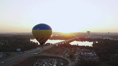 A Colorful Hot Air Balloon Gliding Gracefully Over a Stunning City Skyline at Sunrise