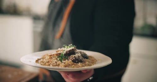 Chef Holding Plate of Steaming Gourmet Food