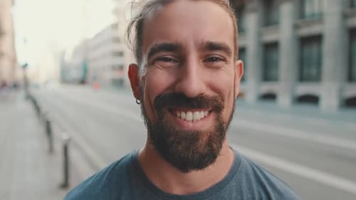 Smiling Man with Beard Standing on City Street