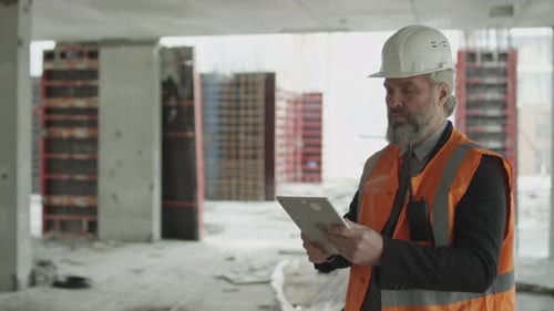 Mature Contractor in Safety Uniform at Construction Site