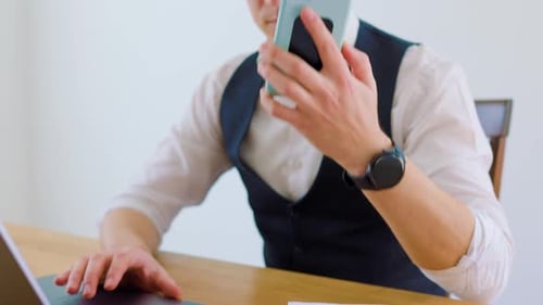 Young Adult Talking on Phone While Typing at Desk