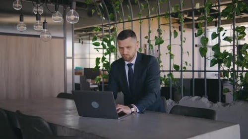 Male Businessman Working in a Modern Office at a Laptop Portrait of a Male Boss in a Formal Suit A