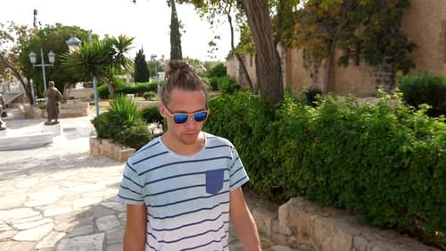 Modern Man In Sunglasses Walking In Tropical City. Stylish Man In Sun Glasses Enjoy Summer Walk. ...