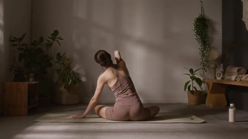 Female Yoga Practitioner Rotating and Stretching Shoulders