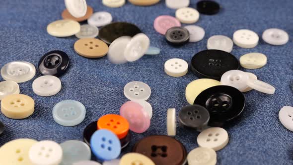 Plastic multi-colored buttons fall on denim. Slow motion., Slow Motion ...