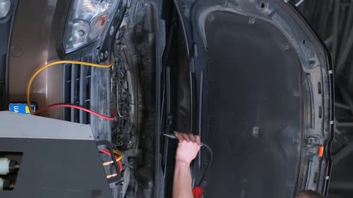 Man Repairing Car in a Mechanic Shop