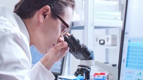 Focused Scientist Using Microscope in Laboratory Setting