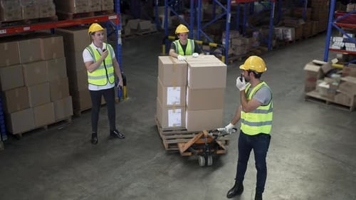 Blue collar workers are working at warehouse.