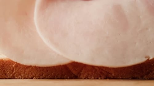 Ham Slices Being Placed on Bread Close Up
