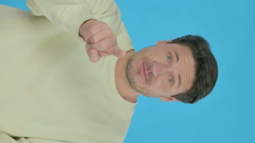 Young Man Inviting People on Blue Background, Vertical Video