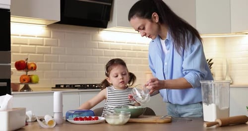 Woman and Child Baking Together in Kitchen
