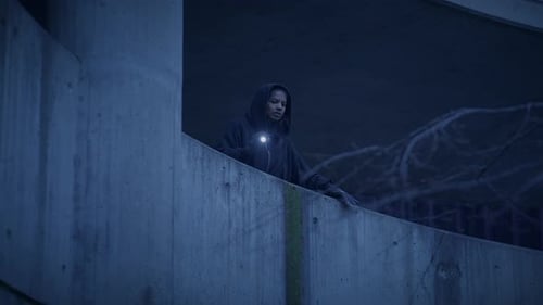 Young Adult with Flashlight on Ledge at Night
