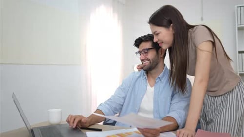 Man and Woman Collaborating on Computer in Office