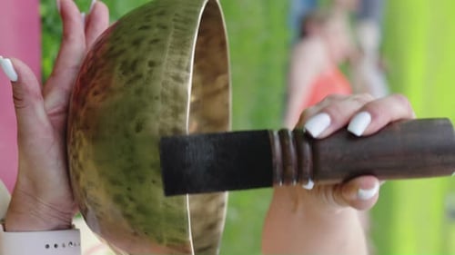 Woman Playing Singing Bowl for Meditation Outdoors