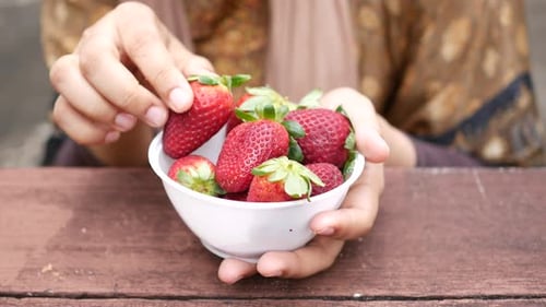 Women Hand Pick Strawberries in a Bowl