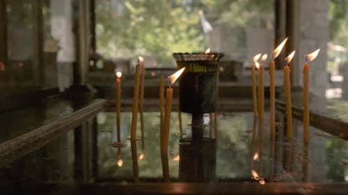 Slow motion shot of candles burning in a greek temple.