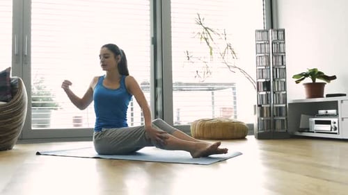 Woman Practicing Yoga and Stretching on Exercise Mat