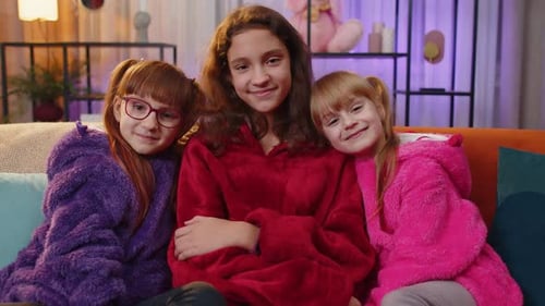 Three Happy Young Girls Smiling on Sofa