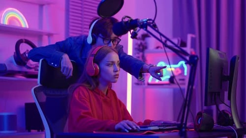 Woman Gaming with Help from Young Adult Man