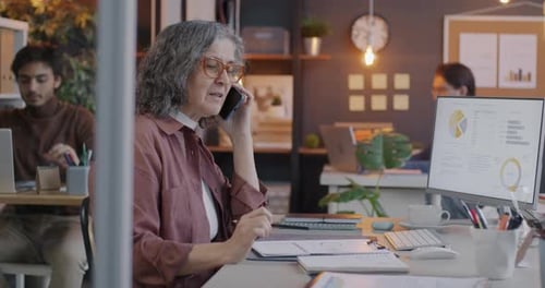 Business Woman Talks on Smartphone in Modern Office