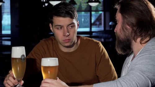 Supportive Friend Comforts a Depressed Young Man Over Drinks at the Bar