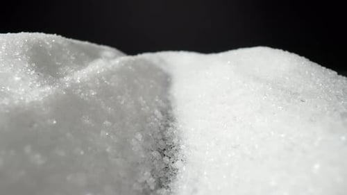Camera focuses in on a mound of white sugar, Macro video