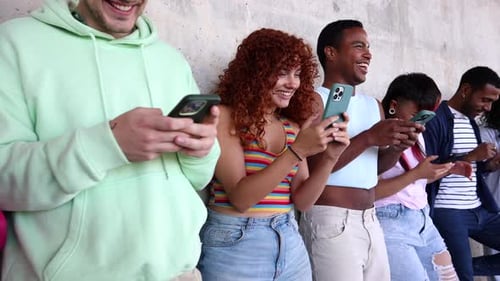 Gemischtrassige junge LGBT-Erwachsene treffen sich, teilen digitale Inhalte auf Smartphones und verbinden sich über