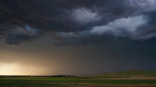 Dramatic Storm Clouds over Rolling Green Fields