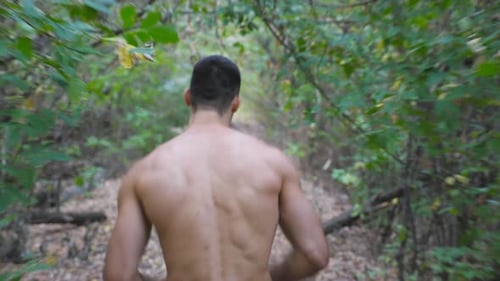 Unrecognizable Muscular Sportsman Running Along Trail at Early Autumn Forest Young Athlete Sprinting