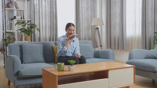 Woman Using Voice Assistant on Smartphone at Home