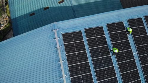 Aerial top view of engineer worker installing solar photovoltaic panels on roof