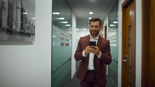 Confident ceo texting message on phone at modern glass office building