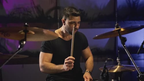 A Young Caucasian Man Drummer Plays a Drum Kit in a Music Studio