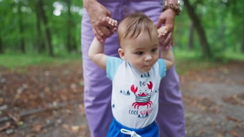 Baby spending time outdoors in the green summer park.