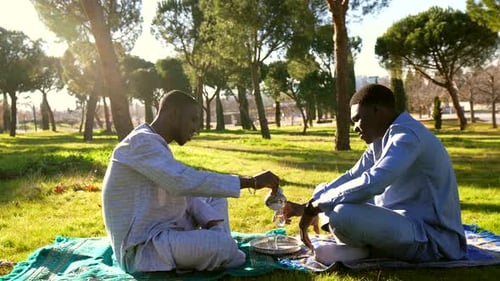 Men Sharing Tea in a Peaceful Park