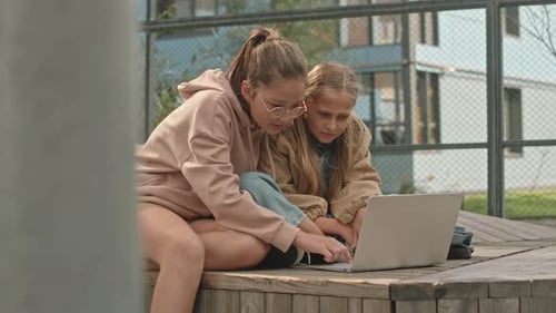 Preteen Girls Studying on Laptop at Playground